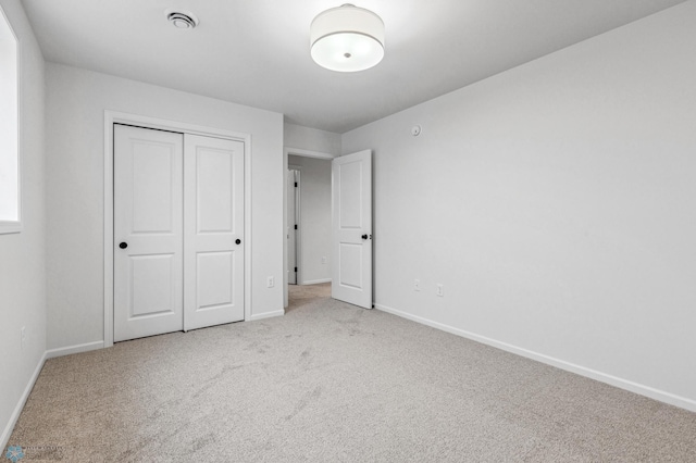 unfurnished bedroom with carpet flooring, a closet, and baseboards