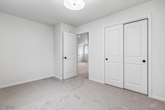 unfurnished bedroom featuring a closet, carpet flooring, and baseboards