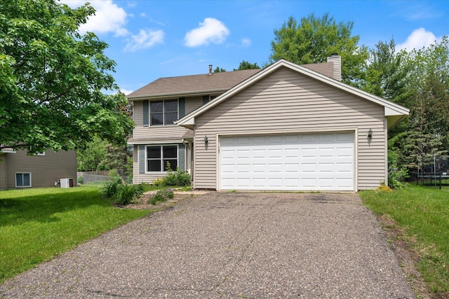 view of front of property featuring a front yard, a garage, and a trampoline