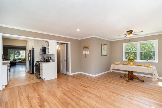 interior space with ornamental molding, ceiling fan, and light wood-type flooring