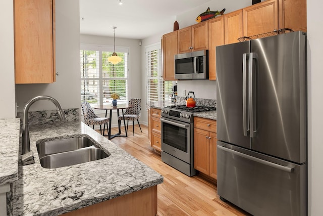 kitchen featuring light stone counters, appliances with stainless steel finishes, and light hardwood / wood-style floors