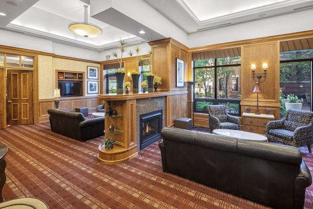 carpeted living room with a tray ceiling and crown molding