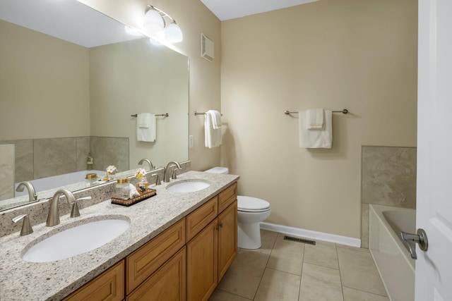 bathroom with a tub to relax in, vanity, toilet, and tile patterned flooring