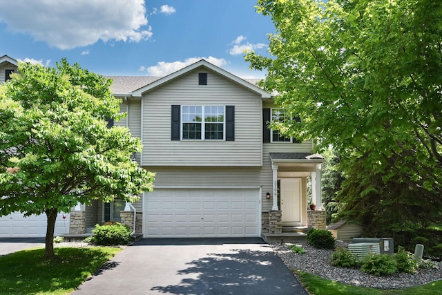 3799 Larabee Ave NE, Saint Michael, MN 55376 - view of front facade featuring driveway, stone siding, a garage, and a shingled roof
