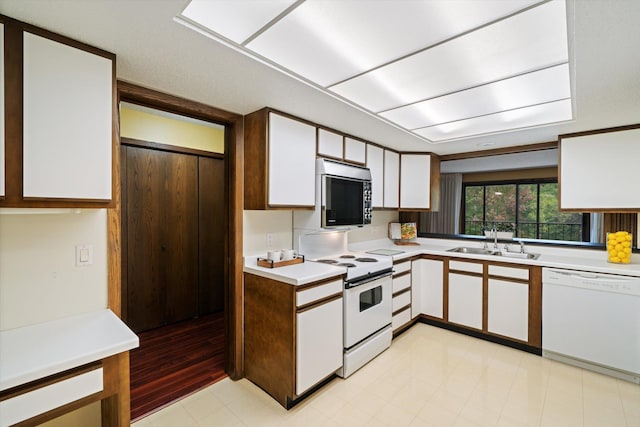 kitchen featuring white cabinets, white appliances, light hardwood / wood-style floors, and sink