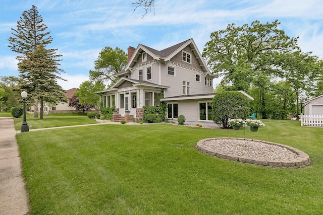 rear view of property featuring a sunroom and a lawn