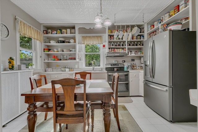 kitchen with white cabinetry, decorative light fixtures, light tile patterned flooring, exhaust hood, and appliances with stainless steel finishes