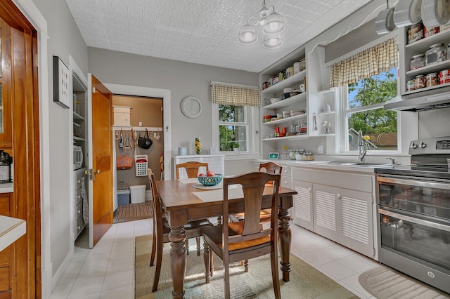 tiled dining room featuring plenty of natural light and sink