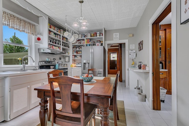 dining space with sink, light tile patterned floors, and a notable chandelier