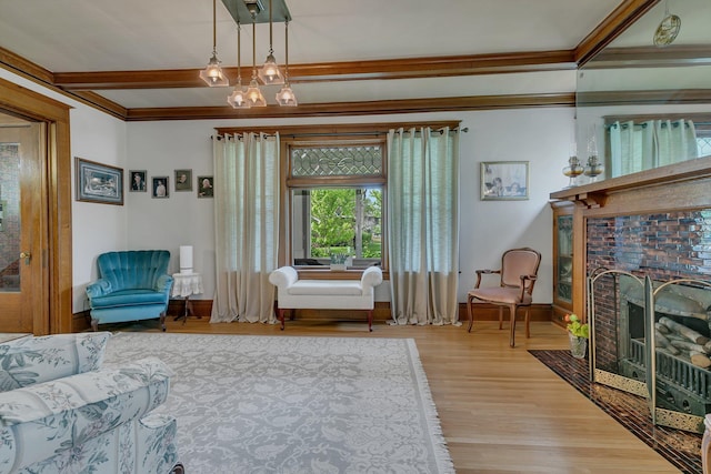 sitting room featuring light hardwood / wood-style floors, ornamental molding, and a fireplace