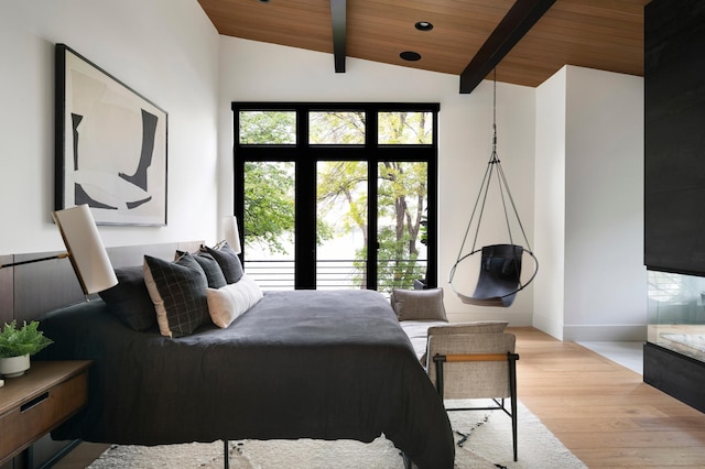 bedroom featuring lofted ceiling with beams, wooden ceiling, and light wood-type flooring