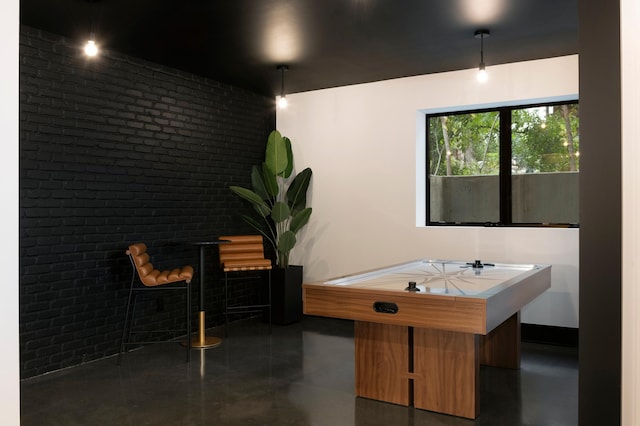 game room featuring brick wall