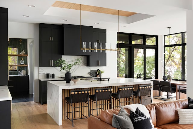 kitchen with pendant lighting, sink, a breakfast bar, and a kitchen island with sink