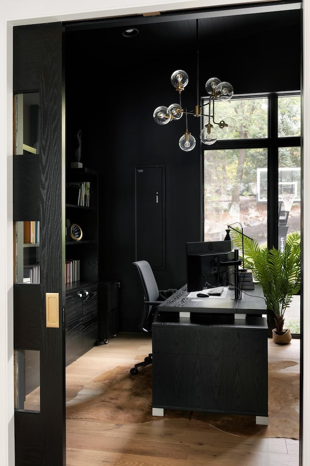 office featuring wood finished floors, plenty of natural light, and a chandelier