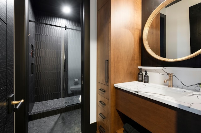 full bath with a stall shower, vanity, and toilet