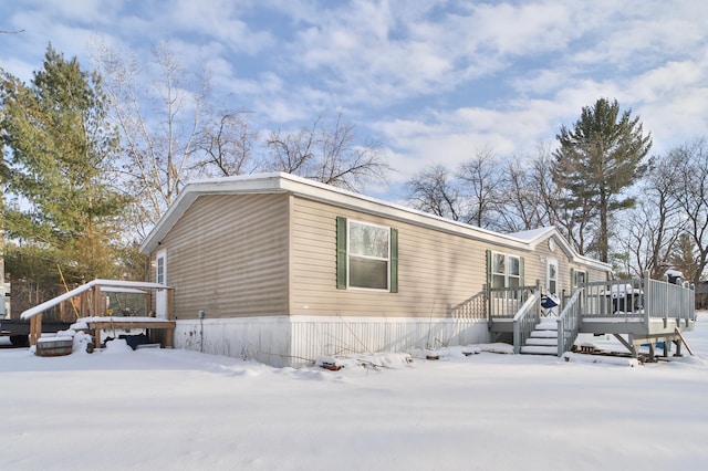 snow covered property with a wooden deck