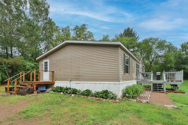 view of home's exterior featuring a deck and a yard