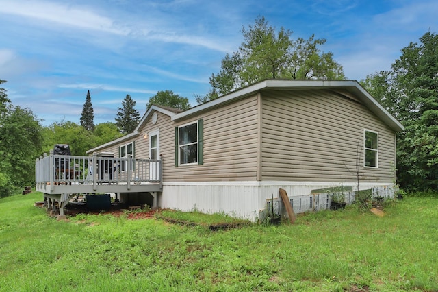 view of home's exterior with a deck and a yard