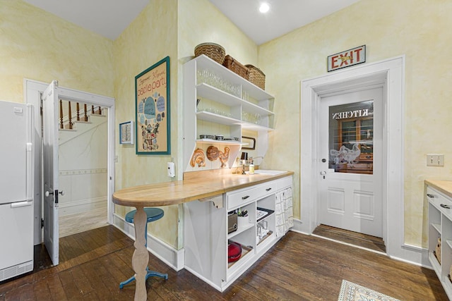 interior space with baseboards and dark wood-style flooring