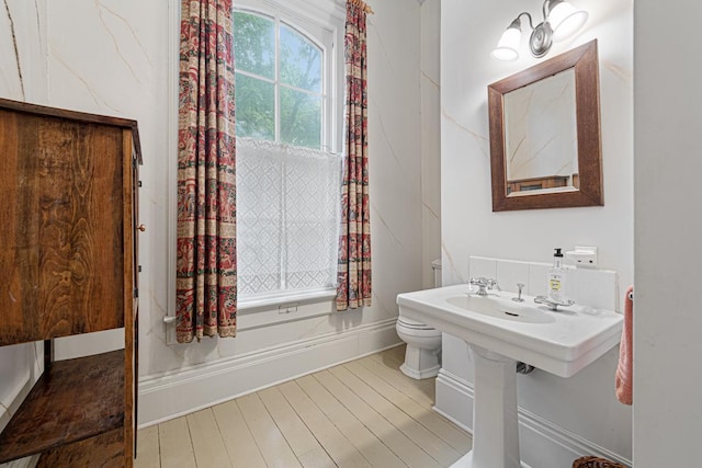 bathroom with toilet and wood finished floors