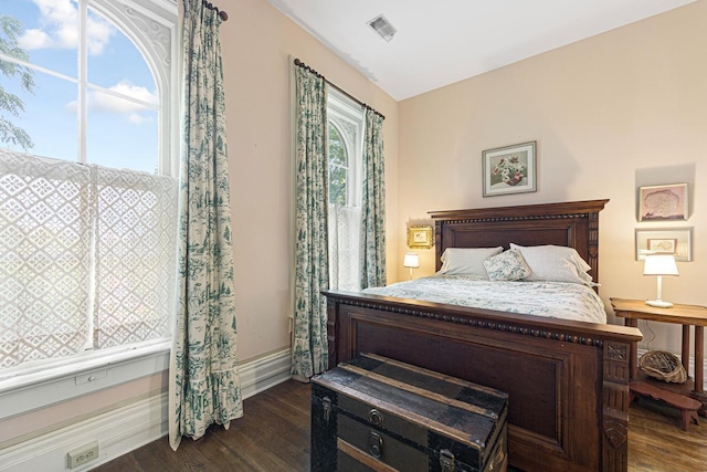 bedroom featuring multiple windows, dark wood-style flooring, visible vents, and baseboards