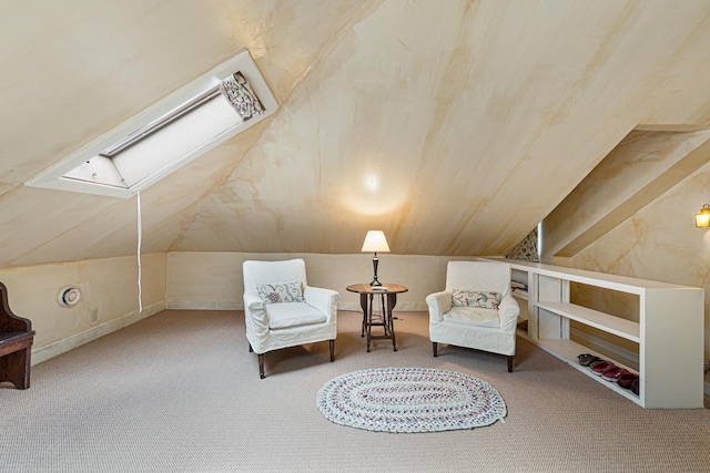 living area featuring lofted ceiling with skylight and carpet flooring