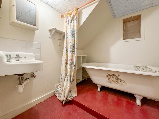 full bath featuring a freestanding tub, a paneled ceiling, and baseboards