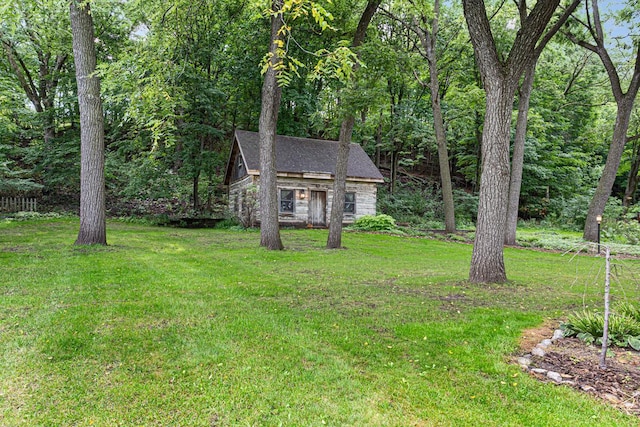 view of front of home featuring an outbuilding, stone siding, and a front yard