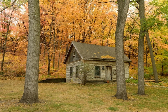 view of front facade with a front lawn and roof with shingles