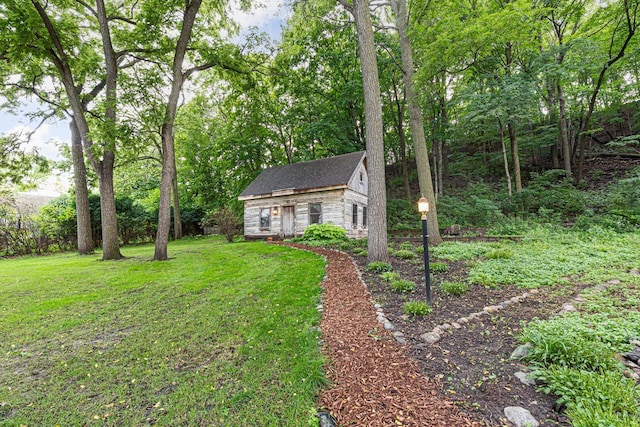 view of front of property featuring stone siding, a front lawn, and an outbuilding