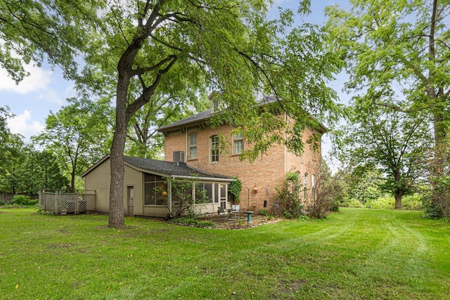 back of house with a sunroom, central AC, and a lawn