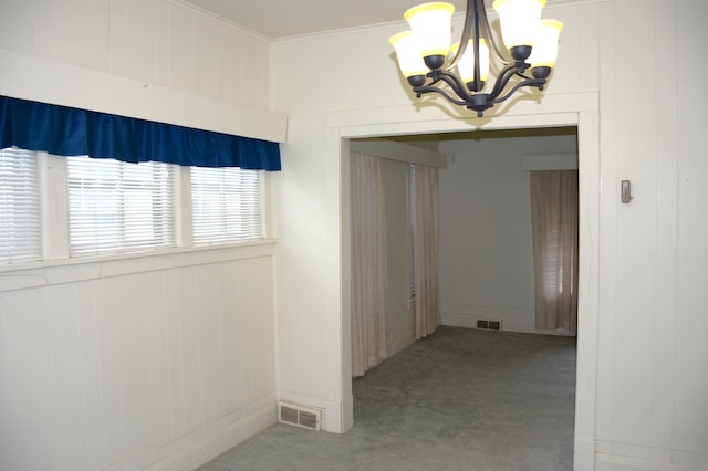 corridor featuring a chandelier, carpet floors, and ornamental molding