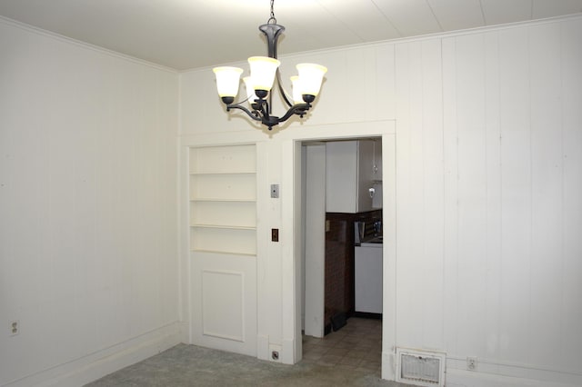 unfurnished dining area featuring a notable chandelier and carpet