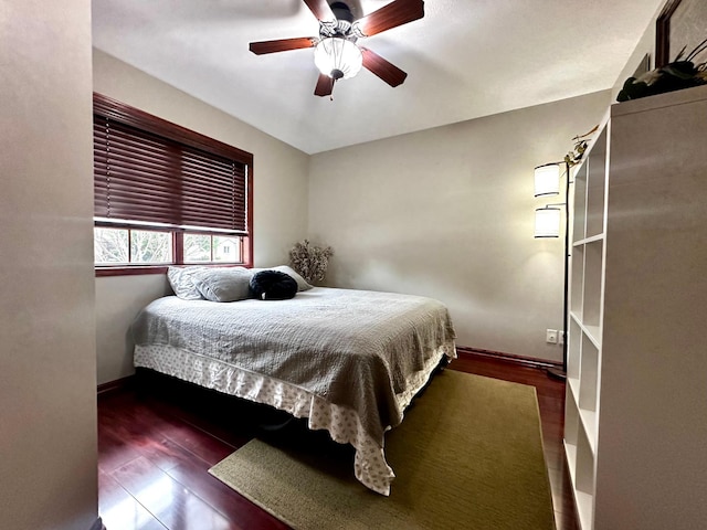 bedroom featuring ceiling fan, baseboards, and wood finished floors