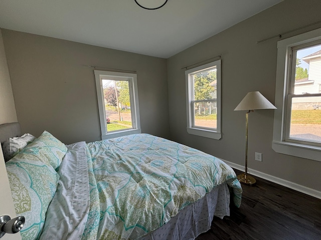 bedroom featuring multiple windows and dark hardwood / wood-style floors