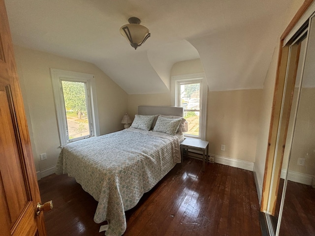 bedroom with dark wood-type flooring and lofted ceiling