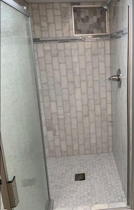 bathroom featuring a shower with door