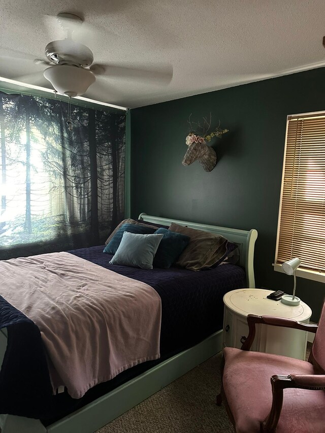 carpeted bedroom with a textured ceiling and ceiling fan