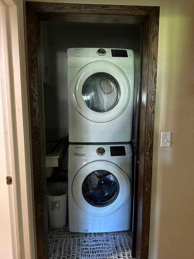 clothes washing area featuring stacked washer / drying machine