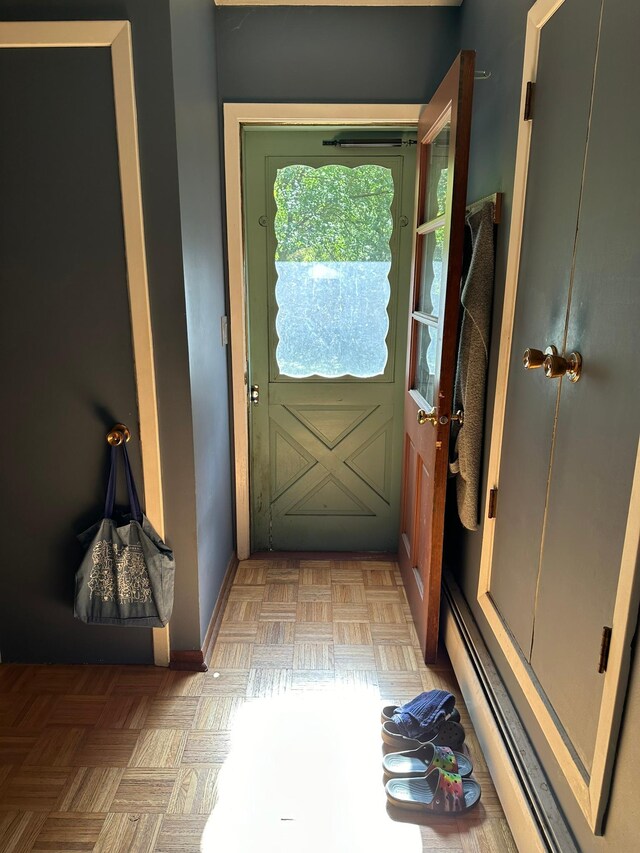 doorway to outside featuring a baseboard radiator and light parquet flooring