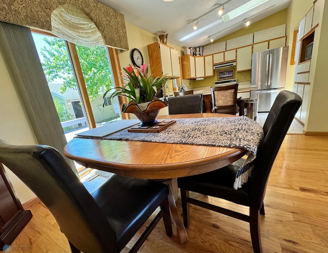 dining area featuring lofted ceiling and light hardwood / wood-style floors