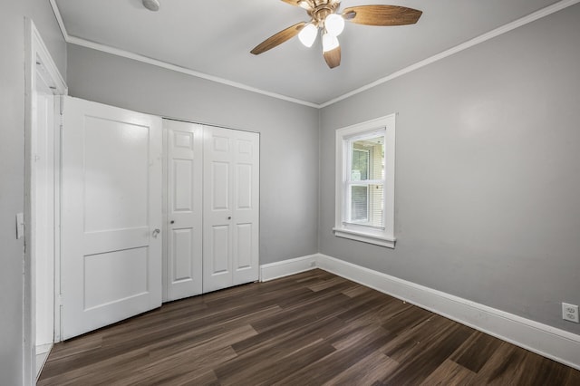 unfurnished bedroom featuring ceiling fan, a closet, dark hardwood / wood-style floors, and crown molding