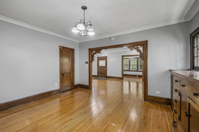 interior space featuring ornamental molding, a chandelier, and light hardwood / wood-style floors