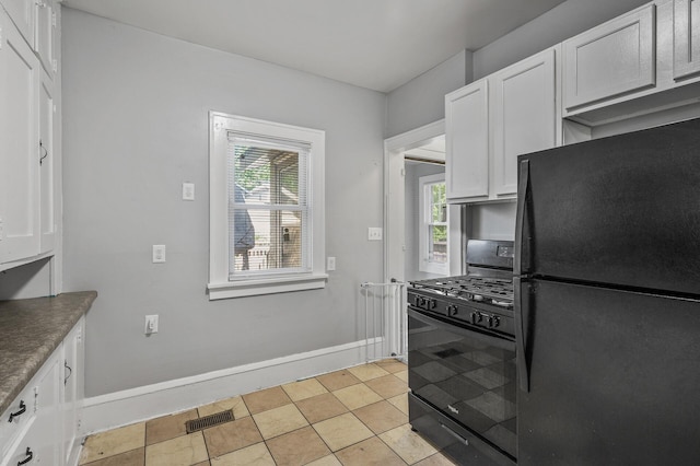 kitchen featuring black appliances, light tile patterned floors, and white cabinets