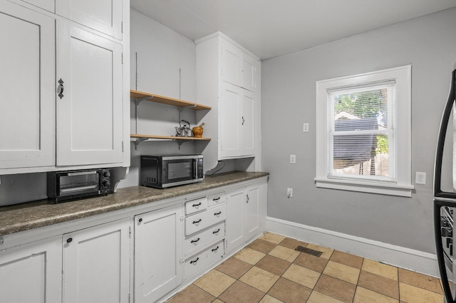 kitchen featuring light tile patterned floors and white cabinetry