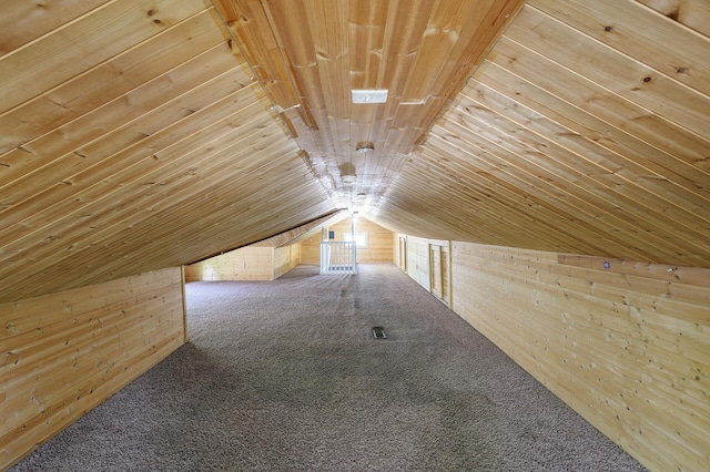 bonus room featuring carpet floors, wood walls, and vaulted ceiling