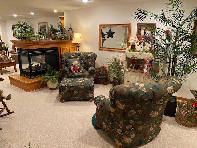 living area with a multi sided fireplace, light colored carpet, and a textured ceiling