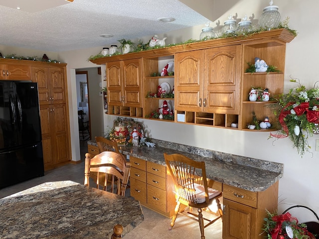 kitchen with black refrigerator and a textured ceiling