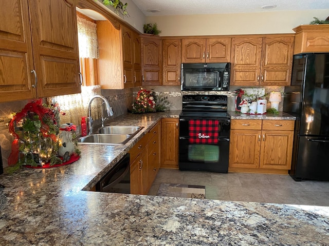 kitchen with black appliances, backsplash, sink, and a textured ceiling