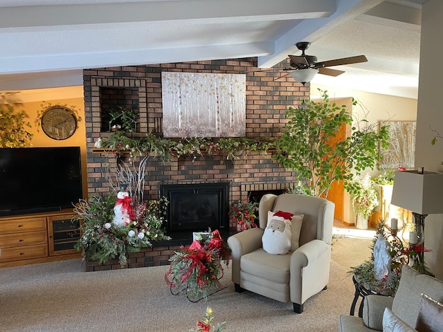 living room with vaulted ceiling with beams, ceiling fan, carpet floors, and a brick fireplace